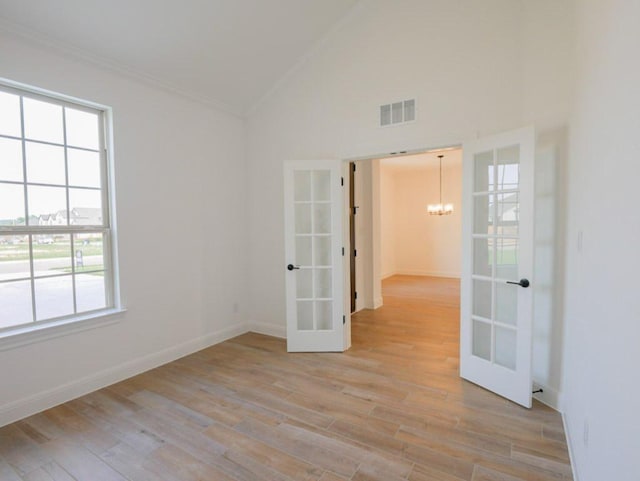 1705 Cayuga St, Leander, TX 78641 - empty room with french doors, lofted ceiling, crown molding, a chandelier, and light wood finished floors