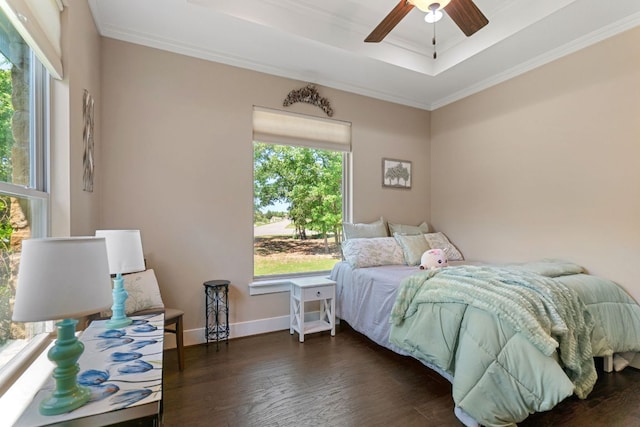 bedroom with baseboards, wood finished floors, ornamental molding, and a raised ceiling