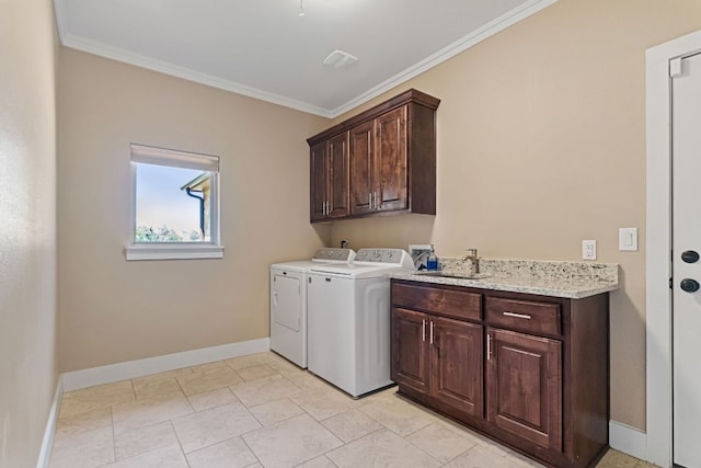 laundry room with a sink, washer and dryer, cabinet space, baseboards, and ornamental molding