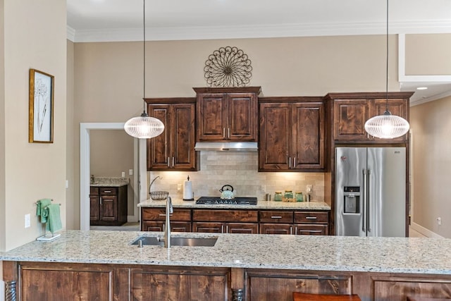 kitchen featuring under cabinet range hood, stainless steel appliances, backsplash, dark brown cabinets, and a sink