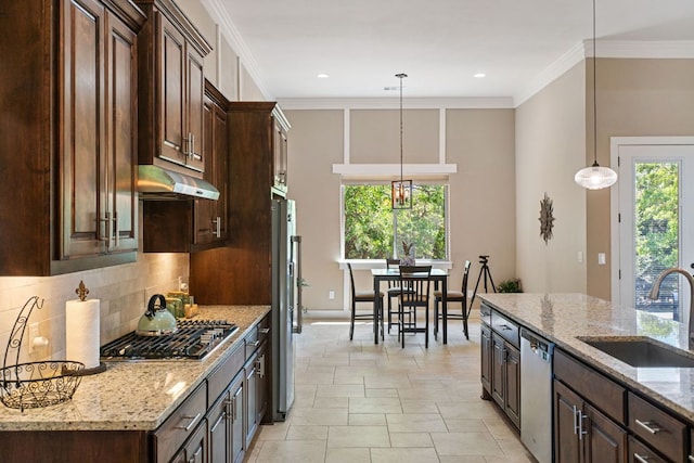 kitchen with dark brown cabinetry, under cabinet range hood, stainless steel appliances, and a sink