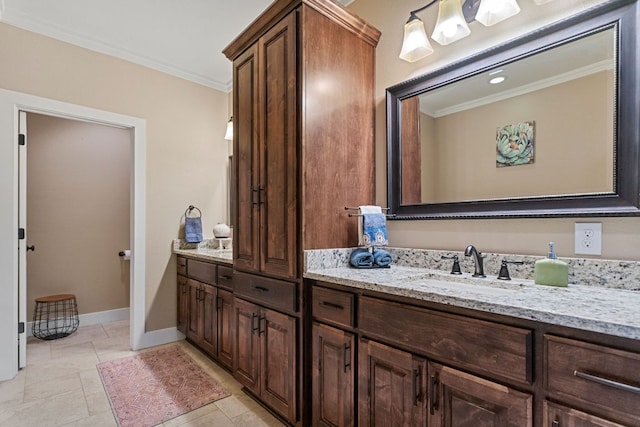 bathroom with baseboards, crown molding, and vanity