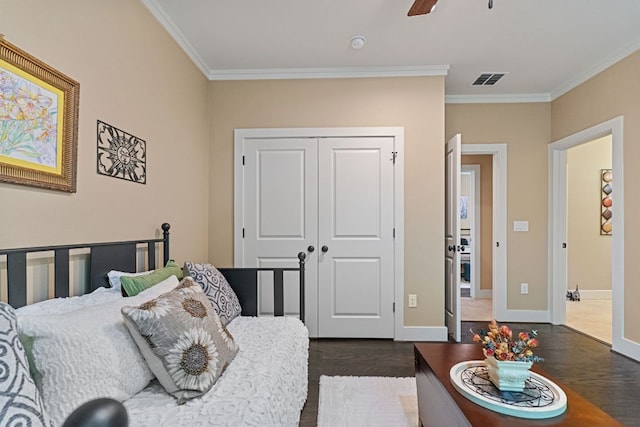 bedroom featuring baseboards, ornamental molding, dark wood-type flooring, and a closet