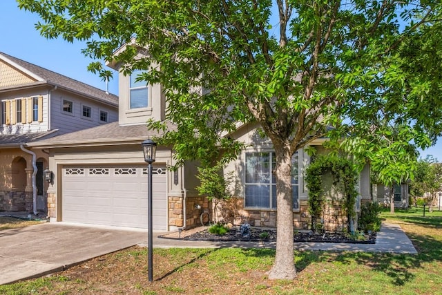 view of front facade with an attached garage, driveway, and stone siding