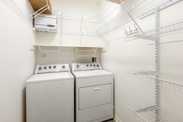 laundry room featuring washing machine and clothes dryer, laundry area, and baseboards