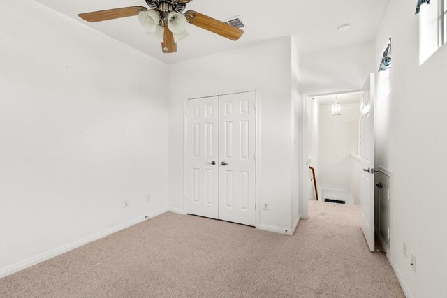 unfurnished bedroom featuring baseboards, a closet, visible vents, and carpet