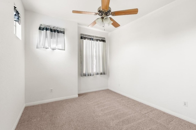 carpeted empty room with ceiling fan and baseboards