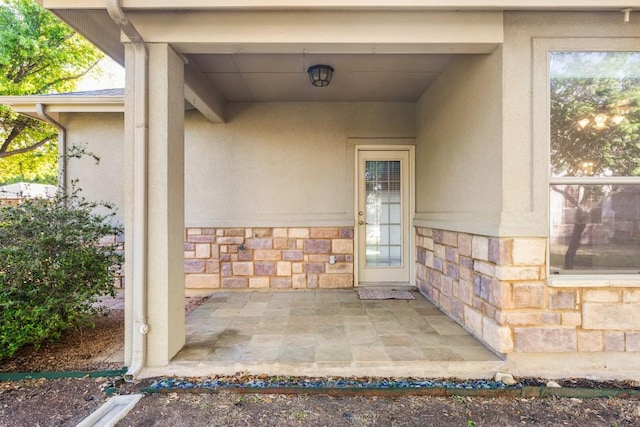 property entrance featuring stone siding and stucco siding