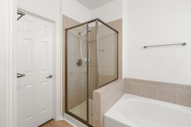 bathroom featuring a shower stall and a garden tub