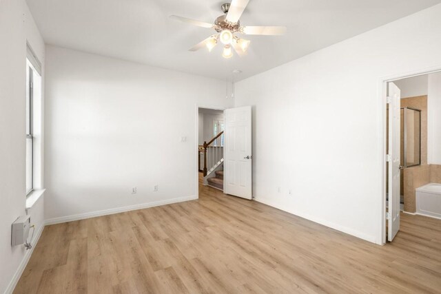 unfurnished bedroom with light wood finished floors, baseboards, and multiple windows