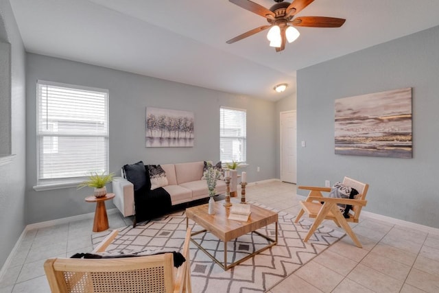 tiled living room featuring lofted ceiling, a ceiling fan, and baseboards