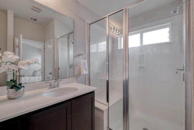 bathroom with ensuite bathroom, visible vents, vanity, and a stall shower