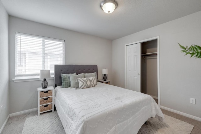 bedroom featuring baseboards, light carpet, and a closet