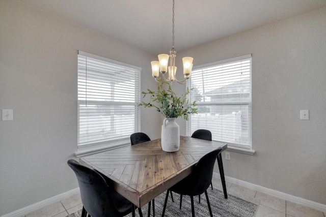 dining space with light tile patterned flooring, plenty of natural light, baseboards, and an inviting chandelier