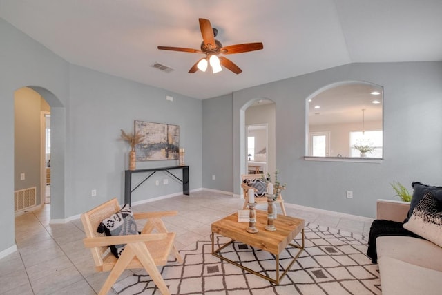 living room with ceiling fan, visible vents, arched walkways, and light tile patterned floors