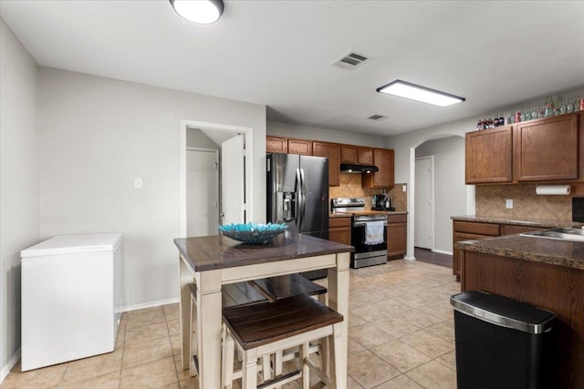 13625 Coomer Path, Pflugerville, TX 78660 - kitchen featuring range with electric stovetop, stainless steel fridge with ice dispenser, fridge, under cabinet range hood, and arched walkways