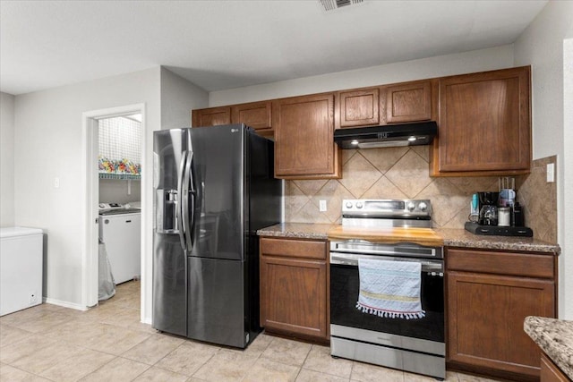 13625 Coomer Path, Pflugerville, TX 78660 - kitchen featuring stainless steel range with electric stovetop, fridge with ice dispenser, under cabinet range hood, separate washer and dryer, and decorative backsplash