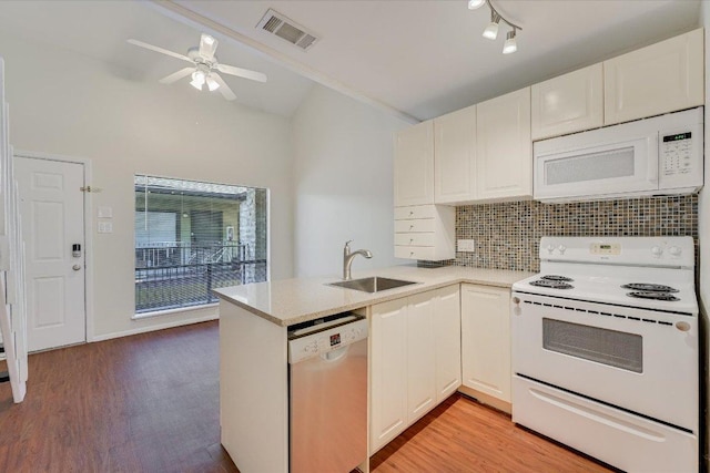 2815 Rio Grande St Unit 211, Austin, TX 78705 - kitchen featuring white appliances, vaulted ceiling, a peninsula, backsplash, and light wood-type flooring
