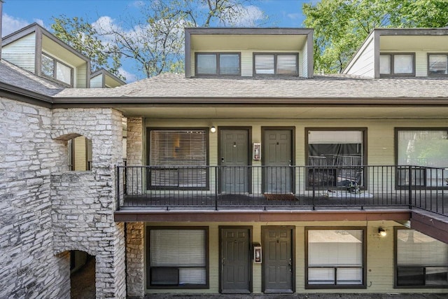 2815 Rio Grande St Unit 211, Austin, TX 78705 - doorway to property with a balcony, stone siding, and a shingled roof