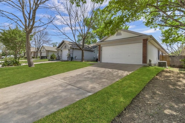 view of front facade with central AC, concrete driveway, fence, brick siding, and a front yard