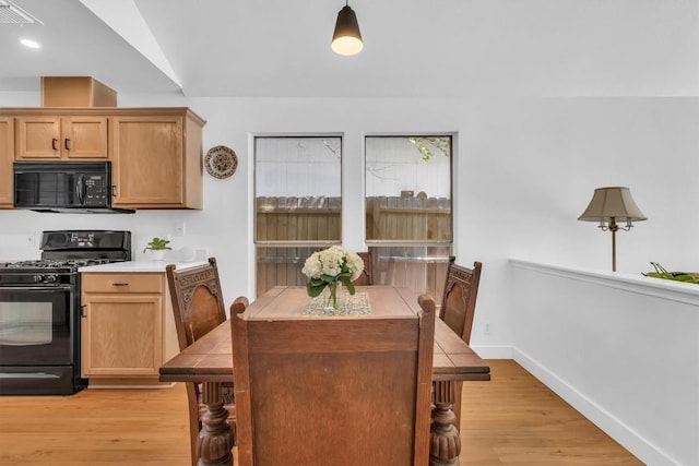 dining space featuring baseboards, light wood-style floors, and visible vents