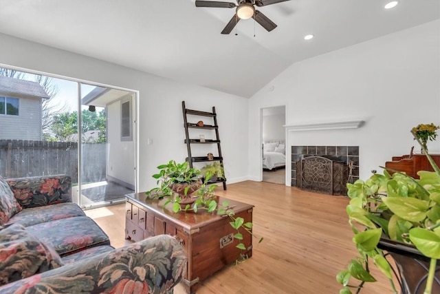 living area with vaulted ceiling, ceiling fan, a tile fireplace, light wood finished floors, and recessed lighting