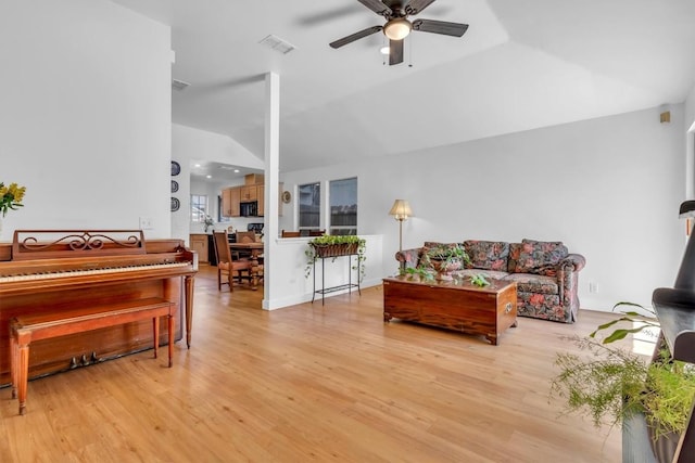 living room with lofted ceiling, visible vents, light wood-style floors, and ceiling fan
