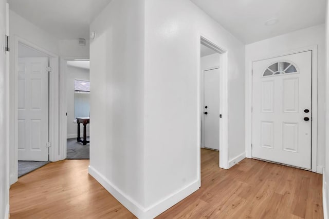 foyer entrance with baseboards and light wood-style floors