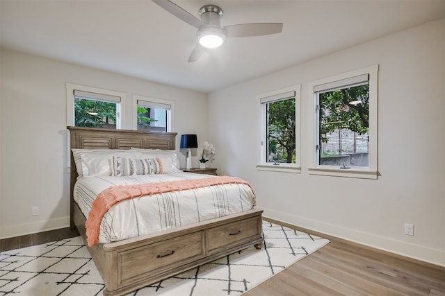 bedroom featuring light wood-type flooring, a ceiling fan, and baseboards