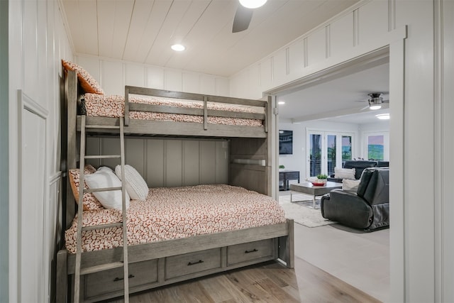 bedroom with a decorative wall, wood finished floors, ceiling fan, access to outside, and recessed lighting