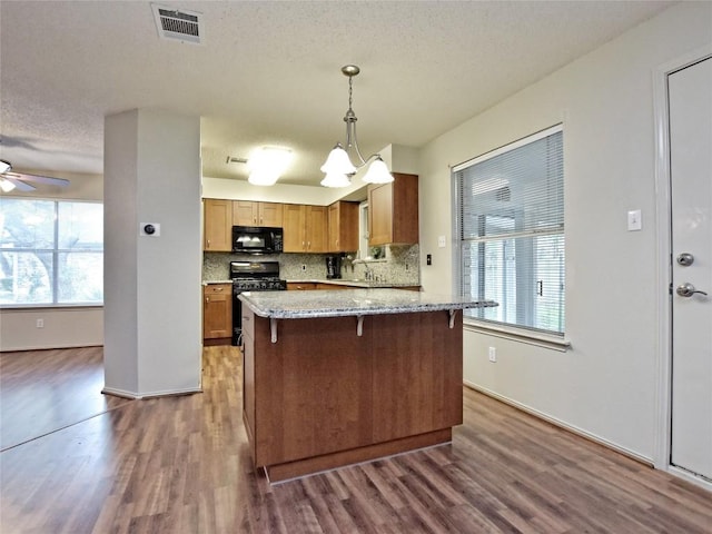 8411 Glen Canyon Dr, Round Rock, TX 78681 - kitchen featuring black appliances, dark wood-type flooring, healthy amount of natural light, and a textured ceiling