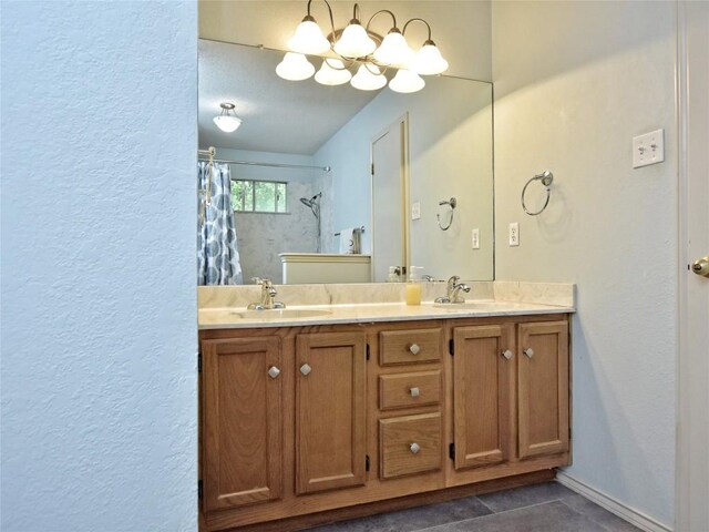 8411 Glen Canyon Dr, Round Rock, TX 78681 - bathroom featuring double vanity, tile patterned floors, a shower with curtain, a textured wall, and baseboards
