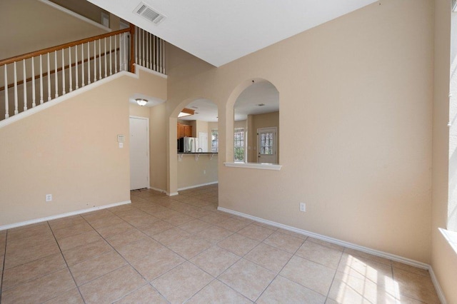 13321 Kirkglen Dr, Austin, TX 78727 - unfurnished living room with baseboards, light tile patterned floors, and arched walkways