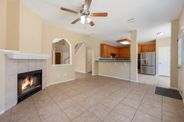 13321 Kirkglen Dr, Austin, TX 78727 - unfurnished living room featuring light tile patterned flooring, ceiling fan, a tiled fireplace, and baseboards