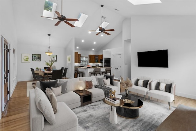 2105 Brackenridge St, Austin, TX 78704 - living room with a skylight, ceiling fan, light wood-type flooring, high vaulted ceiling, and baseboards