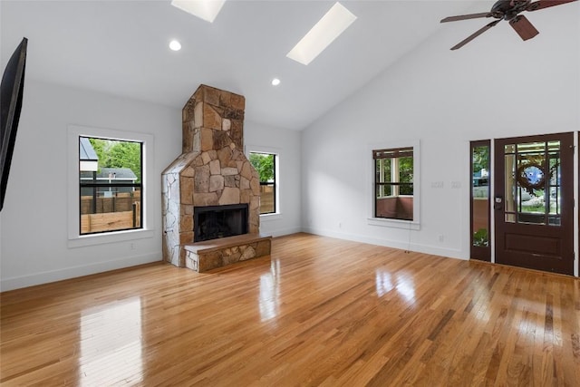 2105 Brackenridge St, Austin, TX 78704 - unfurnished living room featuring high vaulted ceiling, light wood finished floors, a fireplace, a ceiling fan, and a skylight