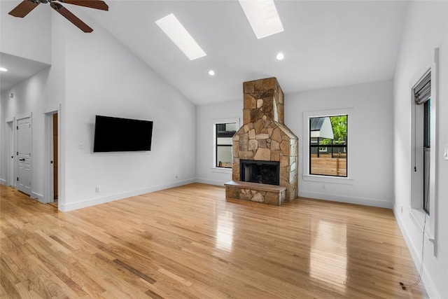 2105 Brackenridge St, Austin, TX 78704 - unfurnished living room featuring a skylight, a fireplace, light wood-type flooring, high vaulted ceiling, and a ceiling fan