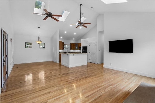 2105 Brackenridge St, Austin, TX 78704 - unfurnished living room featuring a skylight, a ceiling fan, high vaulted ceiling, and light wood-style flooring