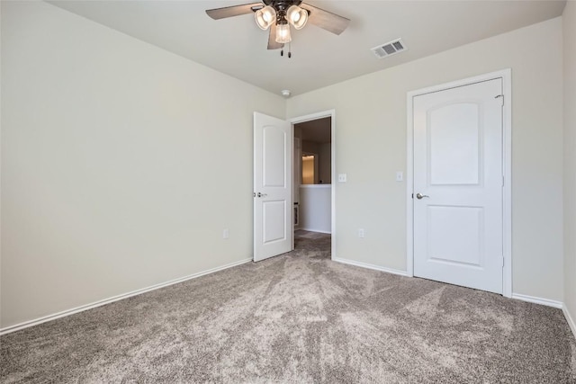 unfurnished bedroom with baseboards, a ceiling fan, visible vents, and carpet floors