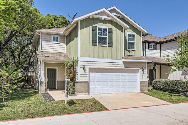 craftsman inspired home featuring concrete driveway, a front lawn, board and batten siding, fence, and a garage
