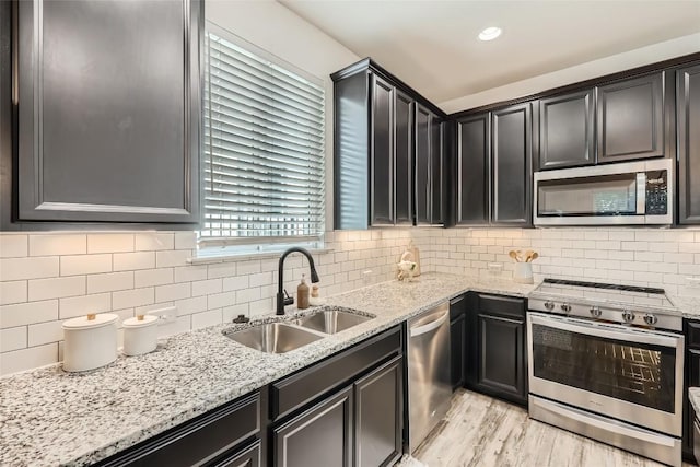 10504 Abana Way, Austin, TX 78748 - kitchen featuring appliances with stainless steel finishes, tasteful backsplash, light stone counters, and light wood finished floors