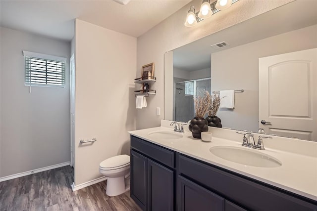 bathroom featuring a shower stall, visible vents, toilet, and a sink