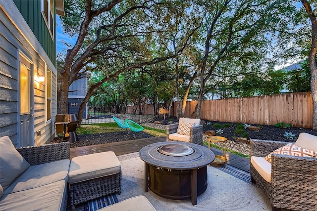 view of patio with a fenced backyard and an outdoor living space with a fire pit