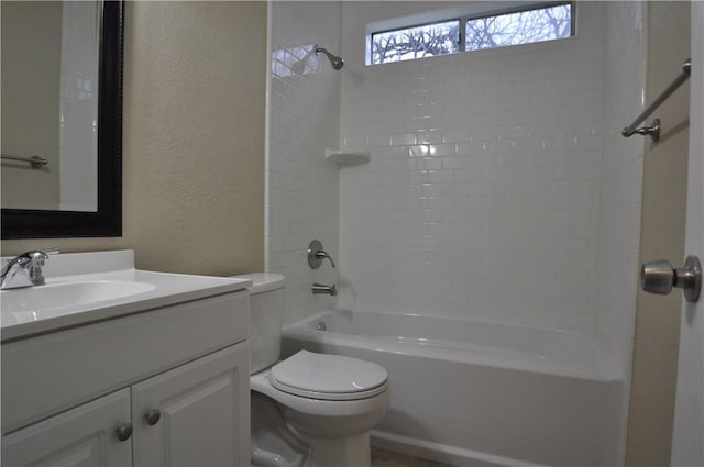 bathroom with a textured wall, shower / bath combination, vanity, and toilet