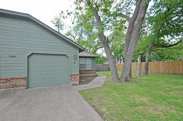 view of yard with a garage, driveway, and fence