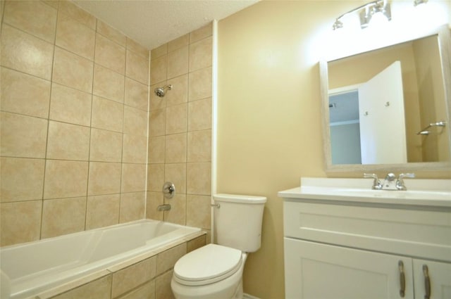 bathroom featuring toilet, vanity, and tiled shower / bath