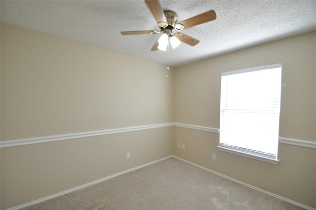unfurnished room with plenty of natural light, a ceiling fan, a textured ceiling, and carpet