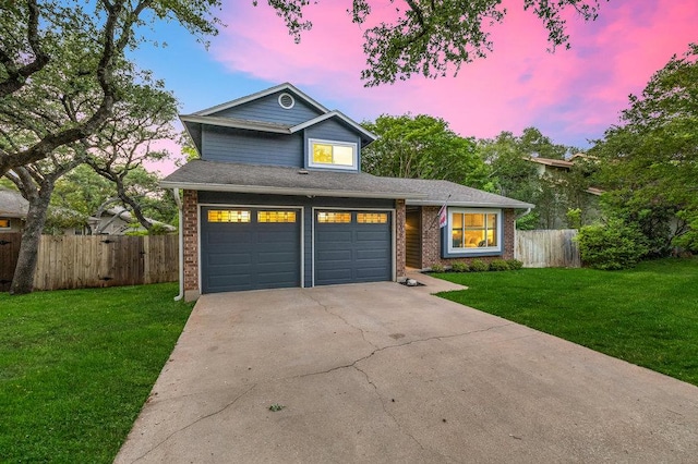 view of front facade featuring brick siding, a front lawn, concrete driveway, and fence