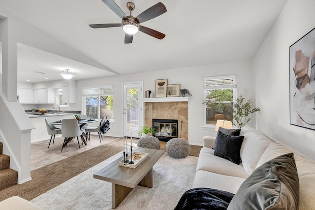 6906 Tesoro Trl, Austin, TX 78729 - living area with lofted ceiling, plenty of natural light, ceiling fan, a tiled fireplace, and light colored carpet