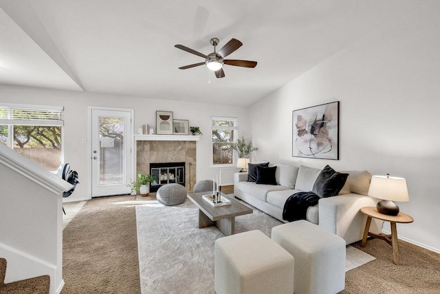 6906 Tesoro Trl, Austin, TX 78729 - carpeted living area with lofted ceiling, ceiling fan, a tiled fireplace, baseboards, and stairs